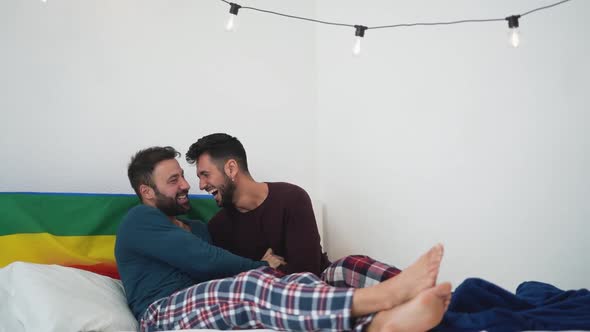 Happy gay couple having tender moments in bedroom