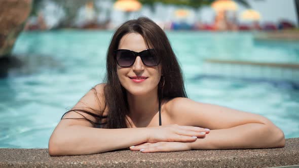 Beautiful Woman in Sunglasses Posing in the Pool