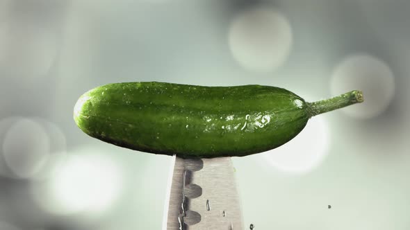 Fresh Green Cucumber Falling Down on Knife Stuck