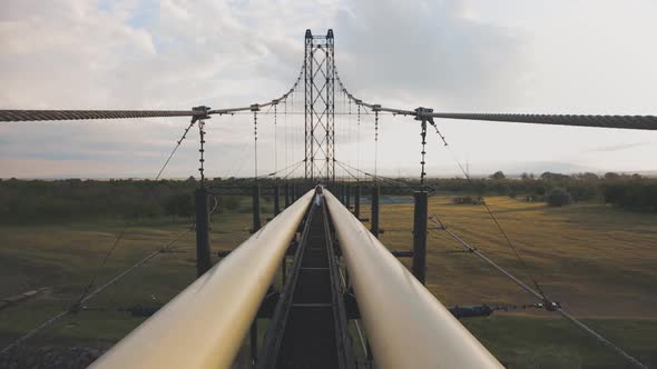 People Walking On A Hanging Bridge Across The Rive