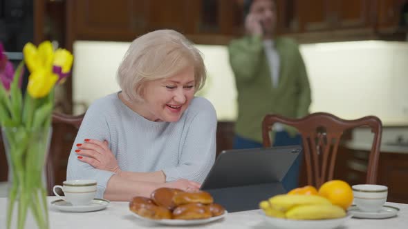 Portrait of Beautiful Relaxed Caucasian Senior Woman Smiling Using Video Chat on Tablet Receiving