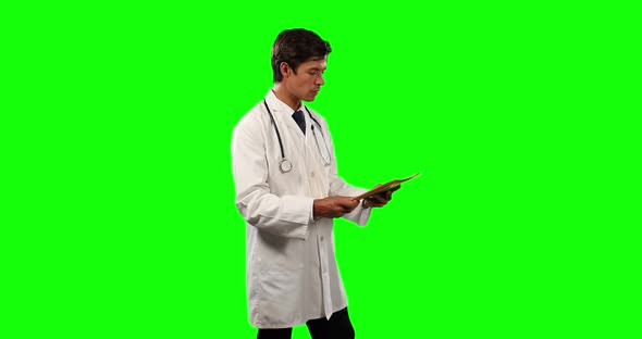 Side view of a doctor checking his papers with green screen