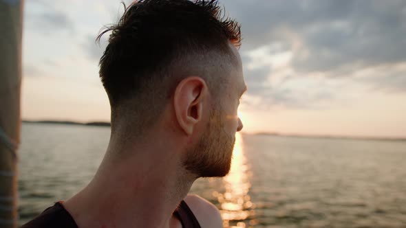 A Man Enjoys the Setting Sun While Walking on a Yacht