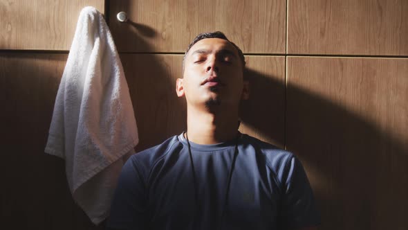 Depressed soccer player looking at camera in the locker room