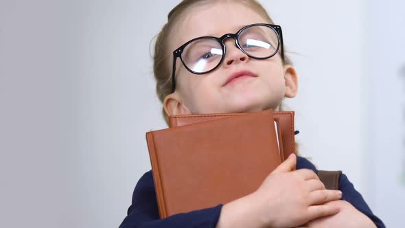 Female Pupil in Eyeglasses Holding Books