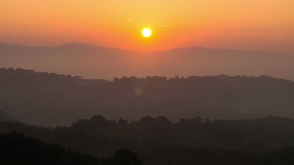 Sunrise time lapse over hills and mountains