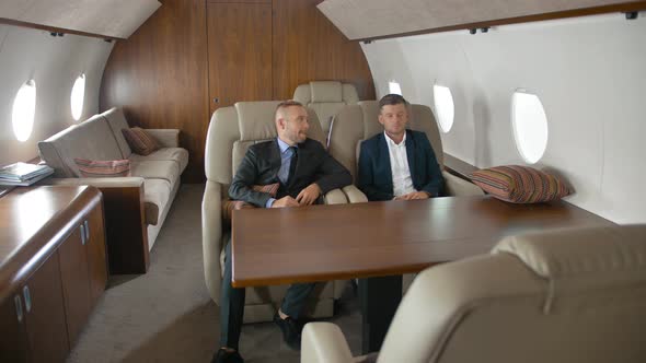 Two Businessmen Talking, Sitting in Private Jet