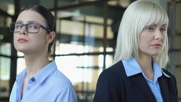 Two Women Looking Different Sides, Competing at Work, Blond and Brunette Rivalry