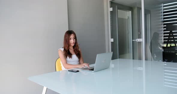 Young Business Woman Typing on Laptop