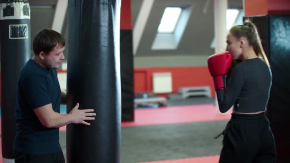 Boxing Training  an Attractive Woman Punching the Bag