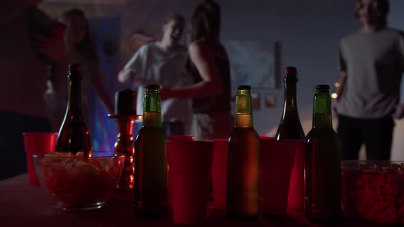 Closeup of Drinks and Snacks Group of Students Dancing at Home Having Party During Coronavirus