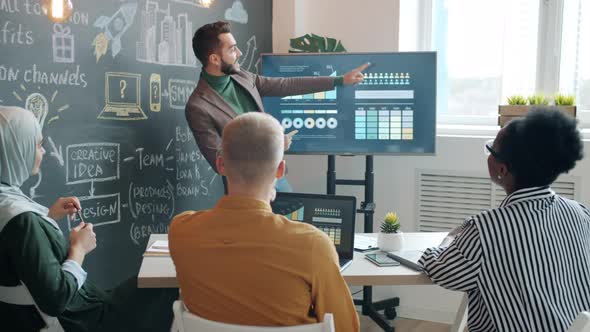 Cheerful Man Making Presentation Discussing Business Growth Dancing Clapping Hands in Office