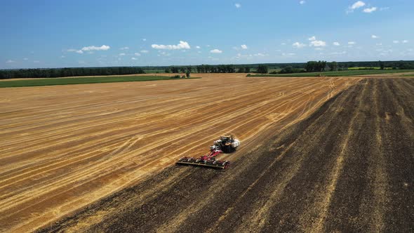 The Tractor Works the Soil After the Harvest Aerial View