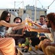 Cheerful multi-ethnic friends laughing and toasting with cocktails at rooftop - VideoHive Item for Sale