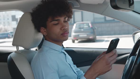 Ethnicity Student is Using Smartphone Sitting in Car Communicating in Social Nets Male User of