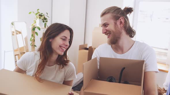 Beautiful Happy Caucasian Pair Holding Boxes with Stuff in Their New Flat in Slowmotion