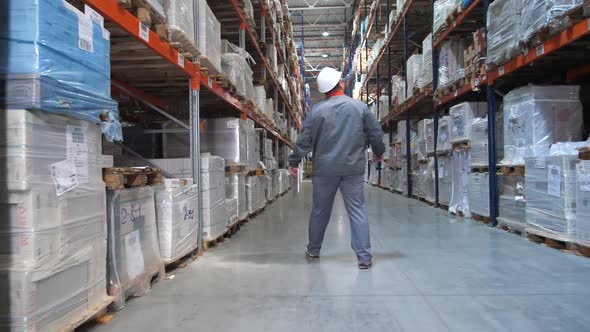 An Employee at a Logistics Warehouse Checks Products