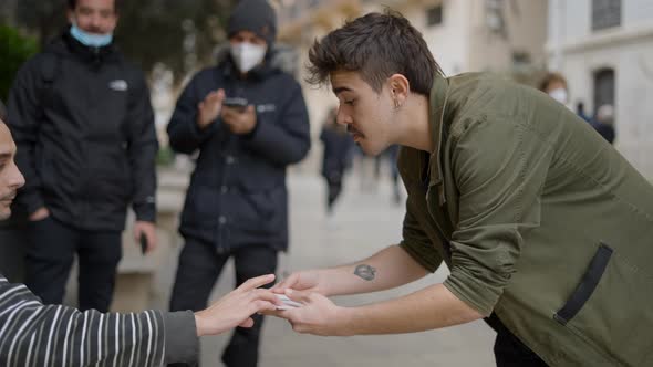 Back View of Magician Showing Magic Tricks to Unknown Person in the Street