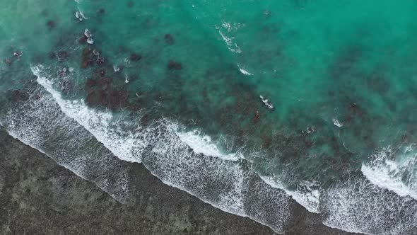 Drone field of view of waves and sea crashing forming patterns in nature La Digue Seychelles