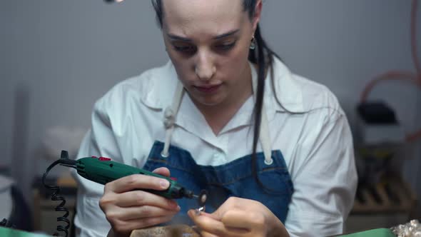 Portrait of Professional Jeweller Polishing Silver Ring with Rotary Handpiece in Slow Motion