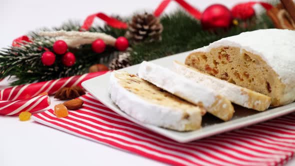 Sliced Traditional Christmas Stollen Cake with Marzipan and Dried Fruit Isolated on Ceramic Plate