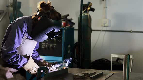 Female welder welding a metal