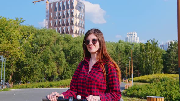 A Woman in Red Plaid Shirt and Sunglasses in the Sunny Park