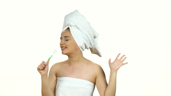 Girl in White Towel on Her Head Dance and Sing Into Toothbrush As in Microphone Isolated on White