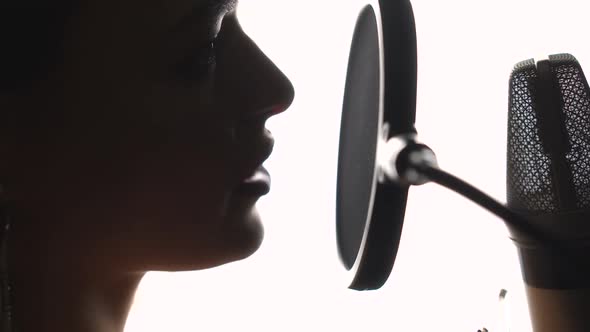 Beautiful young singer who recorded a song in a professional recording studio. Close-up face.