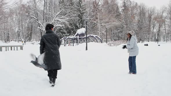 Young Black Woman Playing Snowballs with Her Boyfriend