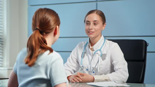 Blonde young woman doctor in white coat with stethoscope