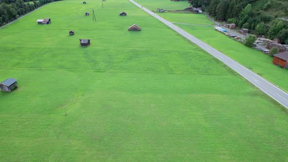 Empty Road in Austrian Valley Between Green Fields in the Alps Aerial View