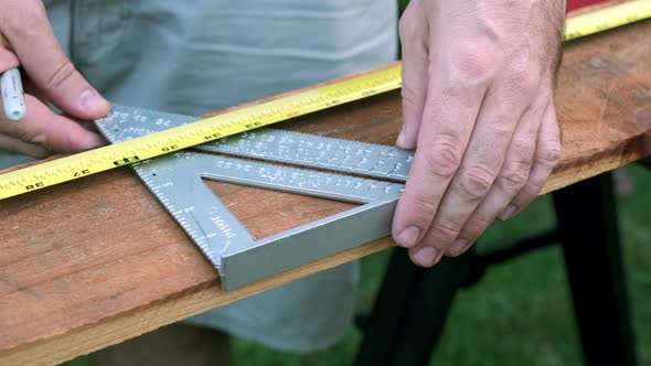 Slow Motion Woodworking Project, Male Hands Measuring Wood with Ruler and Marker in the Daytime