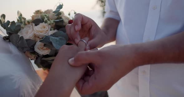 Exchange of rings at a wedding ceremony, close up hands of the bride and groom