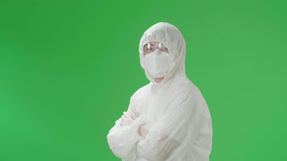 Male Wearing Personal Protective Equipment Uniform Ppe Pose With Arms Crossed In Green Screen Studio
