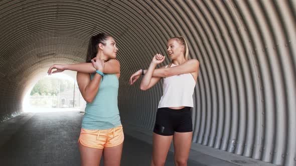 Women with Fitness Trackers Stretching Outdoors