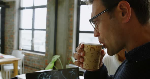 Car designers discussing over desktop pc while having coffee 4k