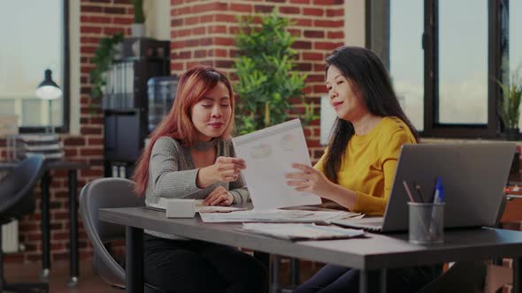 Workers Examining Documents with Investment Charts