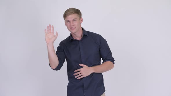 Young Happy Blonde Businessman Waving Hand