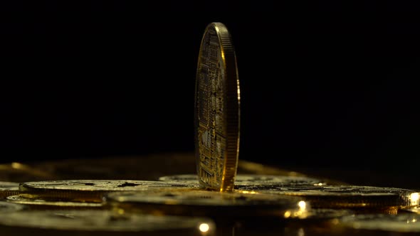 Bitcoin Coins Spinning Change Color on a Black Background. Close Up