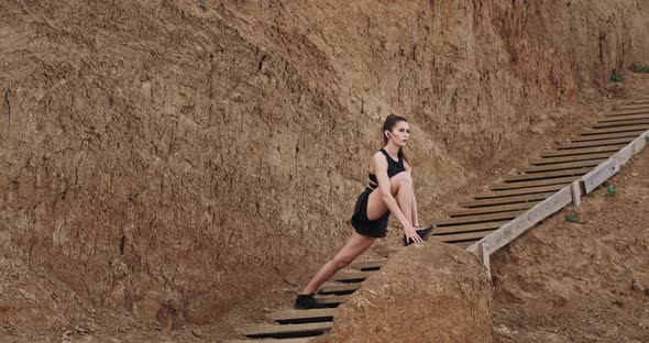 Two Ladies in a Black Sportswear Stretching Legs