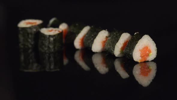 Girl Takes Chopsticks Sushi on a Black Background