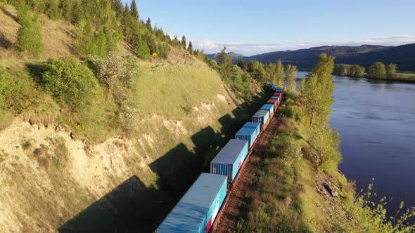 Aerial view of freight train passing by a river