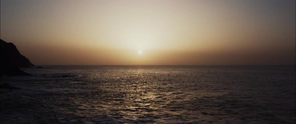 Drone shot of the waves and the sunset