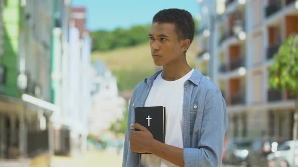 Faithful Mixed-Race Teen Male Looking at Holy Bible in Hands, Religion and God