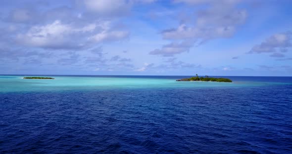 Beautiful fly over clean view of a sandy white paradise beach and blue sea background in vibrant 4K