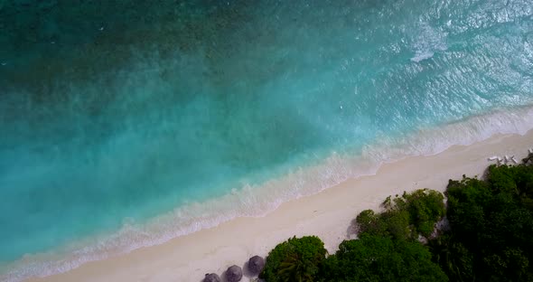 Daytime fly over abstract view of a sandy white paradise beach and aqua blue ocean background 