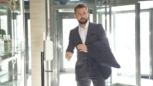 Man in Business Suit Performs Hand Dysingfection in Lobby of the Hotel