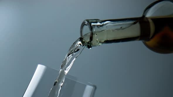 Bottle Pouring White Wine Into Goblet Closeup