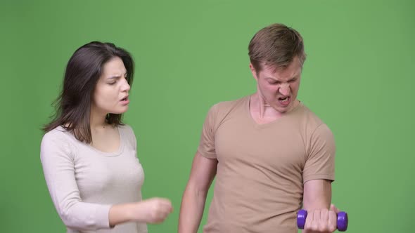 Young Couple Exercising Together and Cheering Each Other